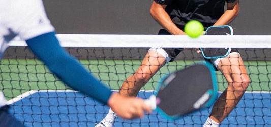 Pickleball players hit a shot during a game.