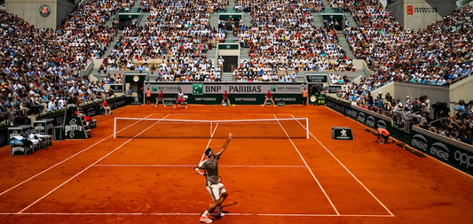 An image taken at a previous French Open of a tennis player about to serve.